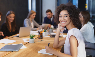 Young businesswoman smiling at camera at meeting