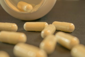 Gelatin capsules with the medicine are scattered across the table.
