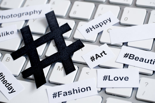 Popular Hashtags Printed With Sign On Paper And On The Keyboard.