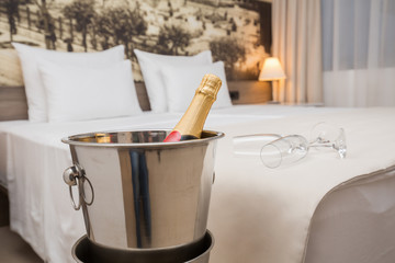 Bottle of champagne and glasses in the hotel bedroom