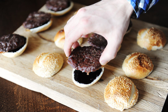 Cooking process of mini burgers. Cutlet on a sesame bun.