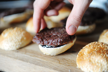 Cooking process of mini burgers. Cutlet on a sesame bun.