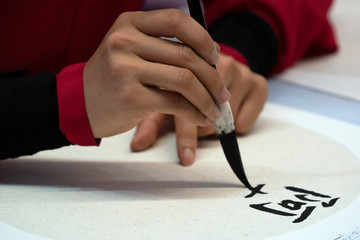 japanese woman writing ideograms with brush