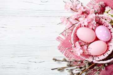 Happy Easter. Congratulatory easter background. Easter eggs and flowers. Background with copy space. Selective focus. Top view.