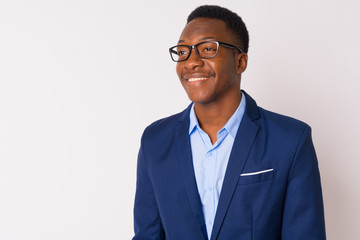 Face of young happy African businessman with eyeglasses thinking