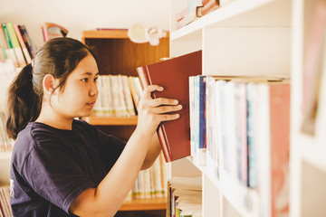 In the library - Young girl student with books working in a high school library.