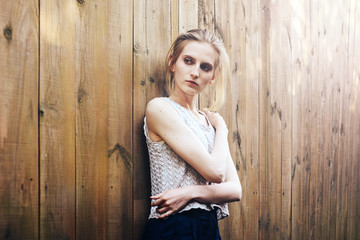 Naklejka premium Attractive girl at wooden fence with the sun's rays.