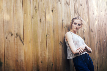 Naklejka premium Attractive girl at wooden fence with the sun's rays.