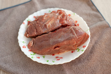 Two pieces of beef meat. Raw beef meat for cooking. Products in the kitchen and dishcloth. Ingredient in the form of beef pulp.