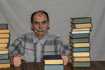 The man looks ahead with a serious look, and his mouth is sealed with adhesive tape. On the tape the inscription "Censored".