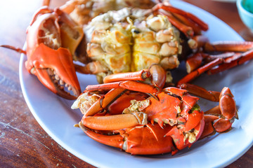 Fresh steamed or boiled crabs in plate on wooden table.