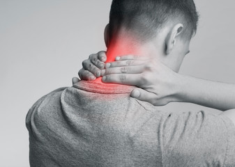 Strong man with neck pain, back view