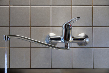 Water leaking from the tap with a damaged gasket. A tap in the kitchen.