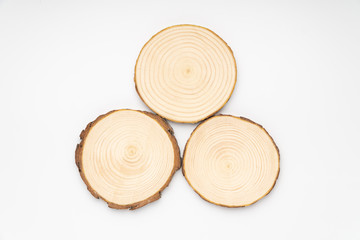 Three pine tree cross-sections with annual rings on white background. Lumber piece close-up shot, top view, isolated.