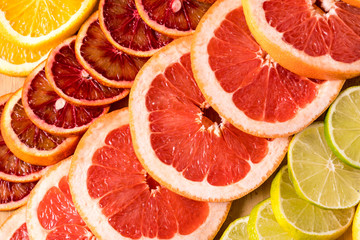 Flat lay slices of different raw fresh citrus fruit.