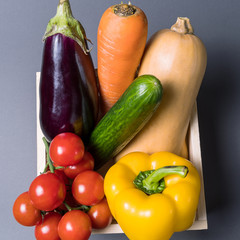 Layout with different vegetables over gray background.