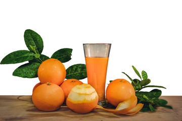 orange fruits and a glass of orange juice on wooden plank