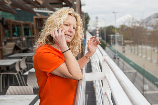 Portrait Of Serious Mature Woman Talking On Mobile Phone At Cafe