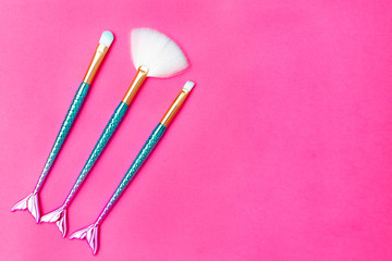 Makeup brush on plastic pink color background. Copy space