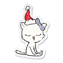 distressed sticker cartoon of a cat with bow on head wearing santa hat