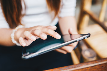Business women hand use tablet computer close up on white screen in cafe