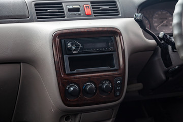 Close-up on climate control buttons and audio system in the interior of an old Japanese car in gray after dry cleaning