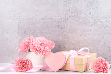 May mothers day handmade giftbox wishes photography - Beautiful blooming carnations with pink ribbon box isolated on fair-faced gray background desk, close up, copy space, mock up