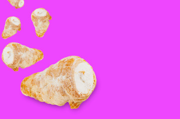 Falling baked rolls with cream on violet background with copy space for your text