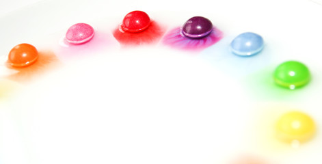 The candies are dissolving in the water and are making a colorful show. 