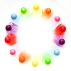 The candies are dissolving in the water and are making a colorful show. 