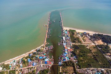 Aerial photos of Cha Am Pier Phetchaburi Province, Thailand shows many fishing boats Parked at the port, preparing to travel to catch fish The blue sea on a sunny day