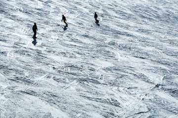 The skiers on the slope during the sunny day. The nice picture of the winter ski atmosphere. Skiers are enjoying the great conditions. 