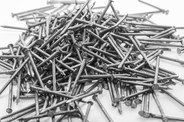 The pile of metal nails lies on the white background.