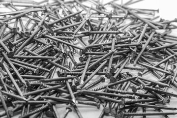 The pile of metal nails lies on the white background.