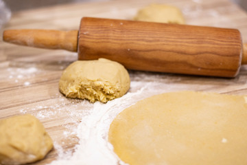 background. a wooden rolling pin with the test lie on a table