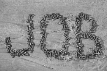 The word "JOB" made from screws on the wooden surface