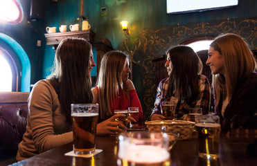group of millennial women having fun drinking beer