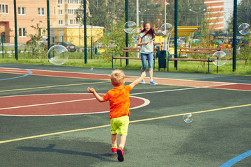 Obraz premium child with mother playing with bubble blower
