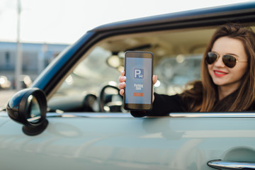 Girl using smartphone app to pay for the parking.