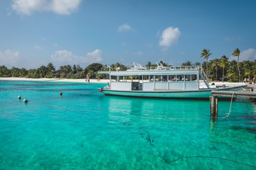 Fototapeta na wymiar Maldives with the turquoise ocean and boats on the awesome water