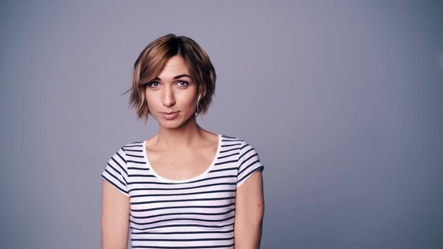 Happy woman in stripped t-shirt looking at camera smiling