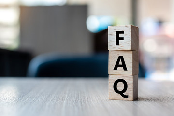 wooden cube with FAQ text ( frequently asked questions) on table background. Financial, marketing and business concepts