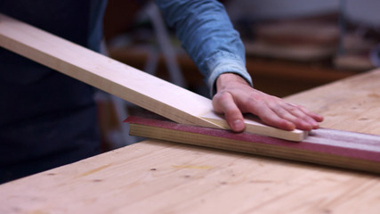 Guitar Maker work with sandpaper on guitar neck