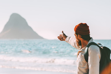 Man traveler showing rock in the ocean enjoying landscape travel healthy lifestyle adventure summer...