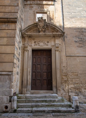 Fototapeta na wymiar Lecce, Puglia, Italy - Medieval historical center in the old town. View and detail of an ancient gate or door. A region of Apulia