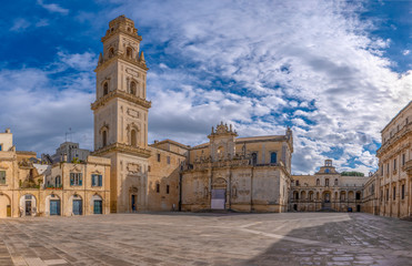 Panorama of Piazza del Duomo square , Campanile tower and Virgin Mary Cathedral ( Basilica di Santa Maria Assunta in Cielo ) , Caritas Diocesana in Lecce - Puglia, Italy. Baroque city of Apulia 