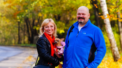 beautiful couple man with woman and dog on walk in forest Park.