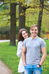 Happy couple expecting pregnancy portrait in park