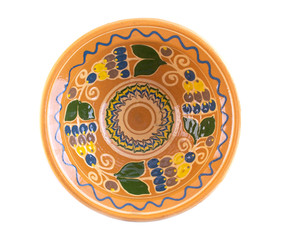 clay plate painted with flowers and fruits  poured on a white background top view