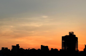 Fototapeta na wymiar Silhouette of buildings in Asia city with evening sunset and orange sky background.
